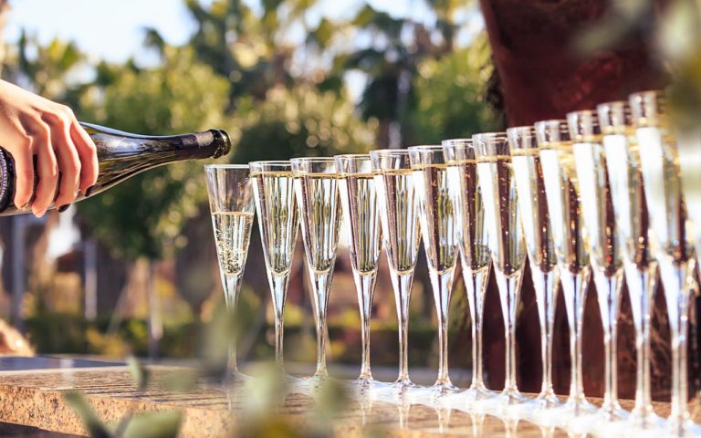 Mousserande vin som hälls upp i det sista glaset i en serie uppradade glas